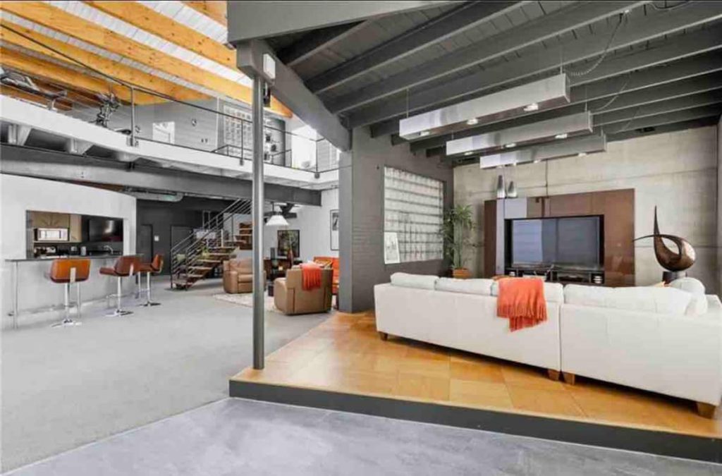 A Stylish, Industrial Loft in Indianapolis With a White Couch and Gray Floors.