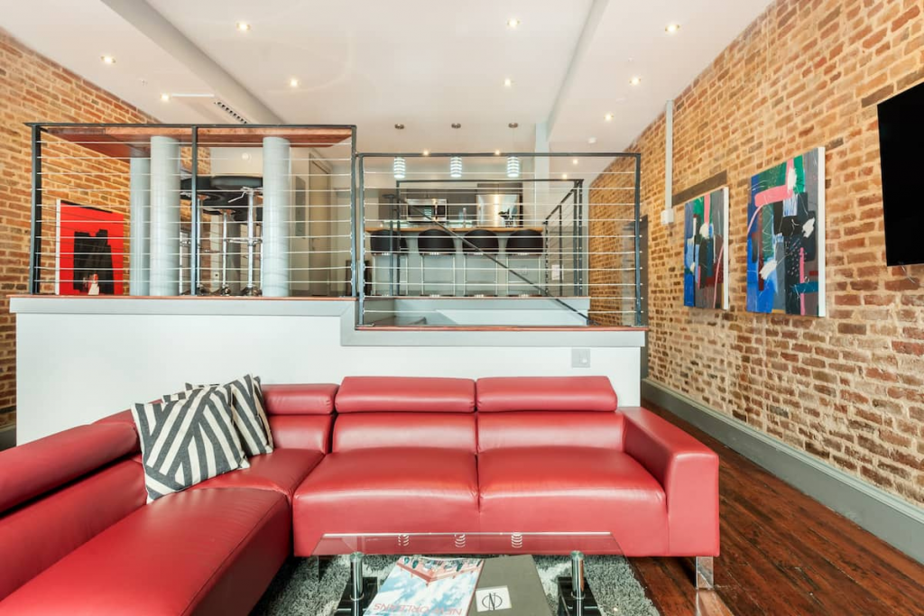 A Retro Loft With Exposed Brick and a Red Couch in New Orleans' French Quarter.