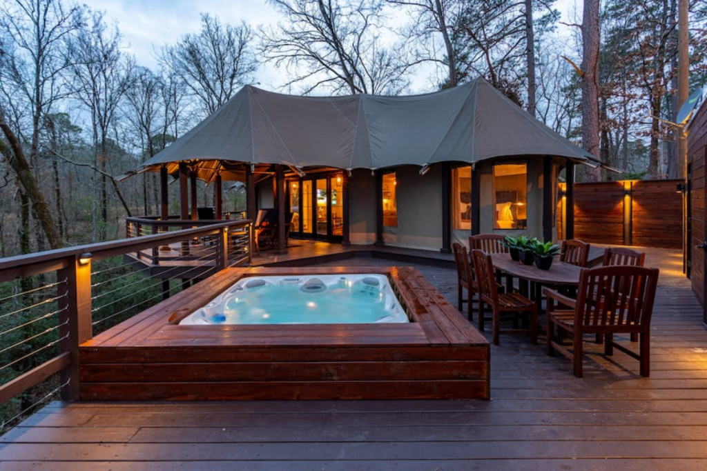 A View of a Hot Tub Airbnb Set Amid the Trees in Arkansas at Dusk.