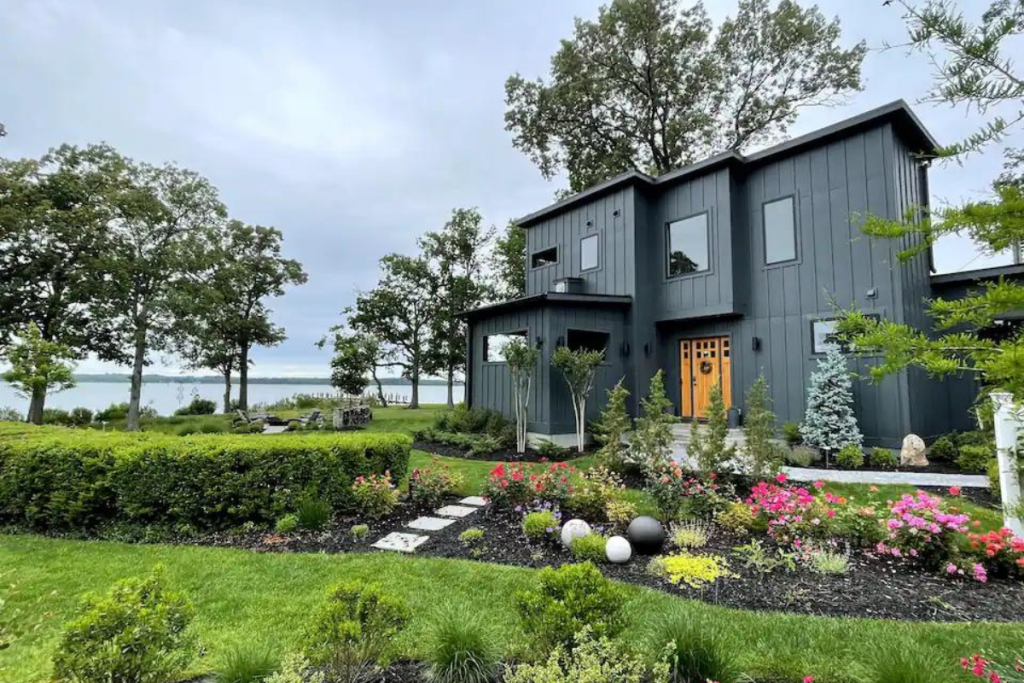 A Coastal Airbnb in Maryland With Bright Green Lawn and Beautiful Flowers.