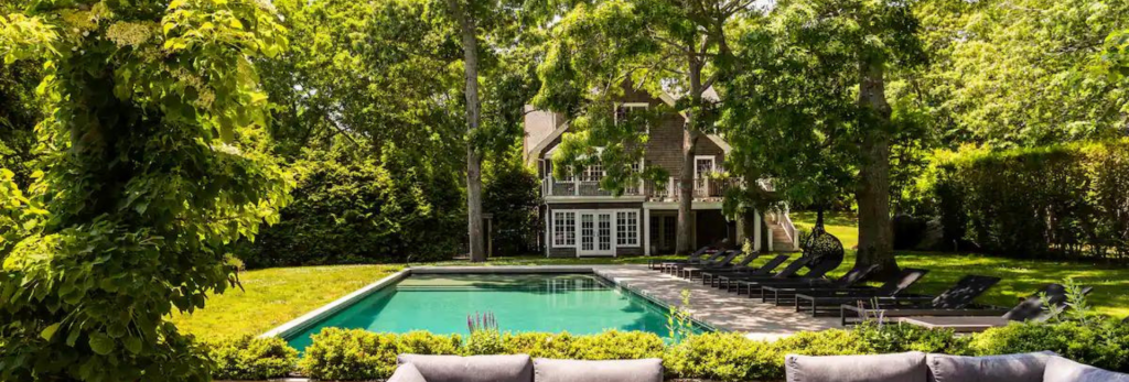 A large pool and yard outside of an airbnb home