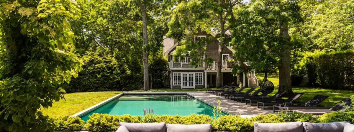 A large pool and yard outside of an airbnb home