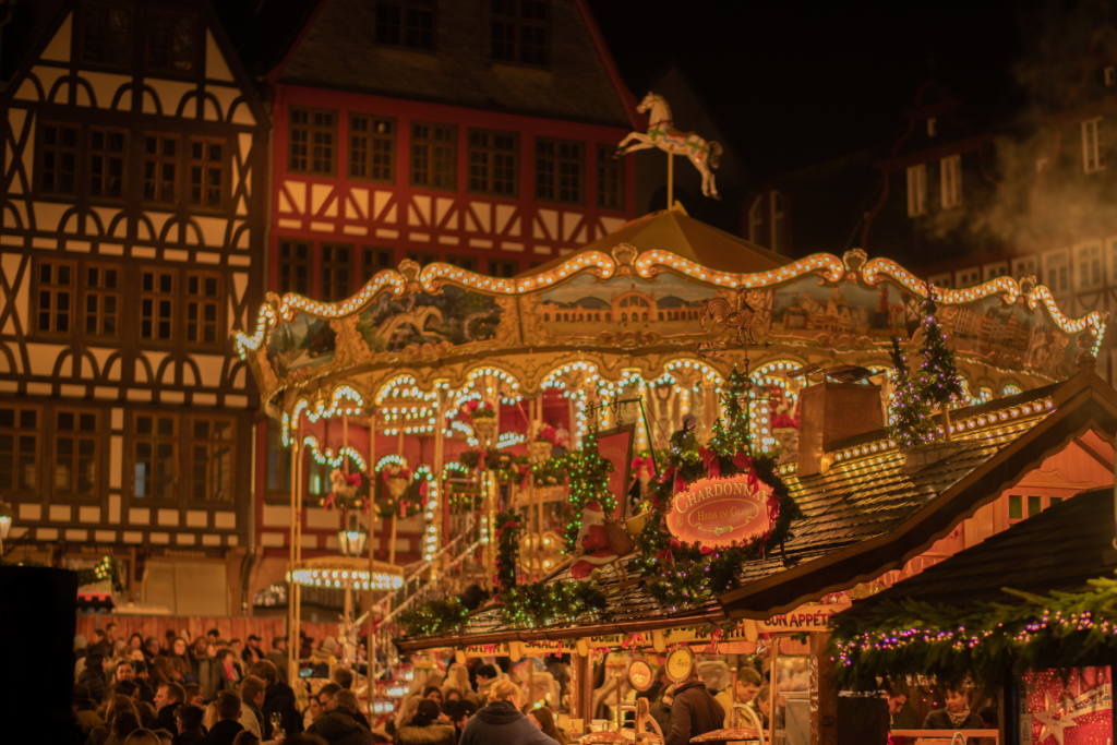 A Carousel Dressed in Holiday Decorations and Twinkling Lights at a Christmas Market in Europe.