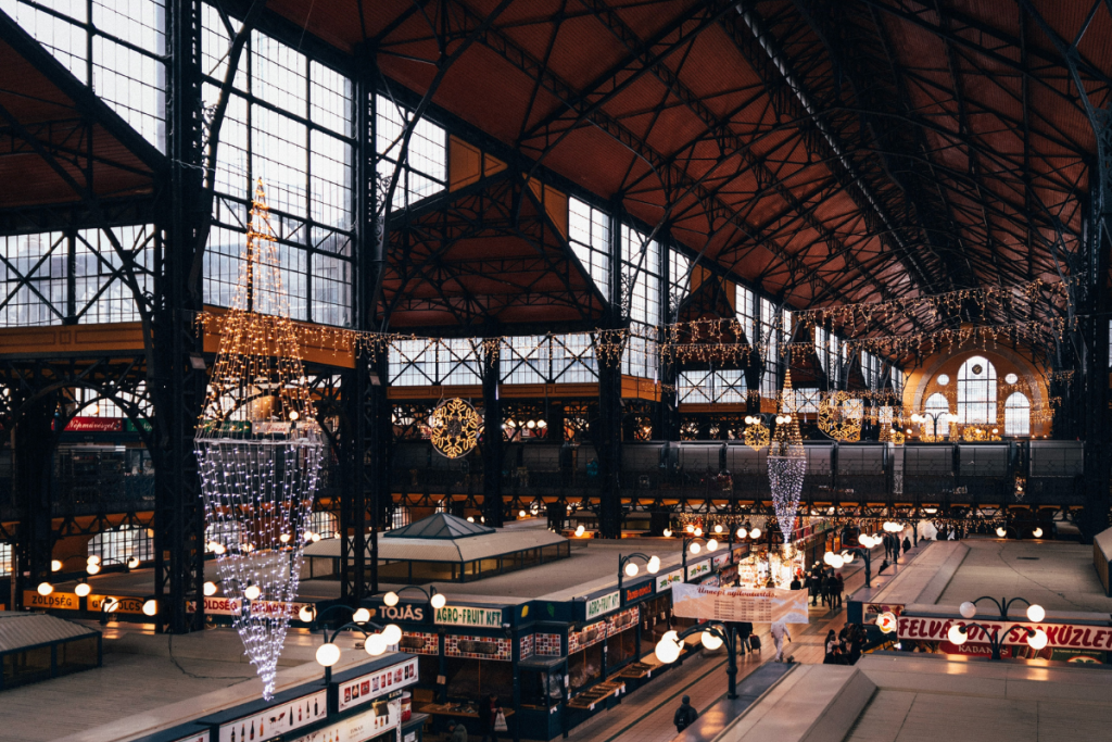 An Indoor Christmas Market in Europe Filled With Christmas Lights and Vendors Selling Handcrafted Goods.