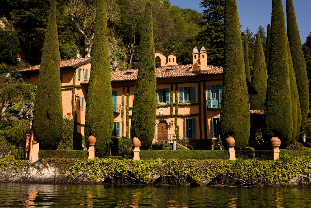 Sun-Soaked Cypress Trees Surround Villa la Cassinella at Lake Como, Italy.