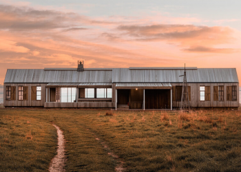 secluded villa with lots of windows in New zealand during a vibrant pink sunset