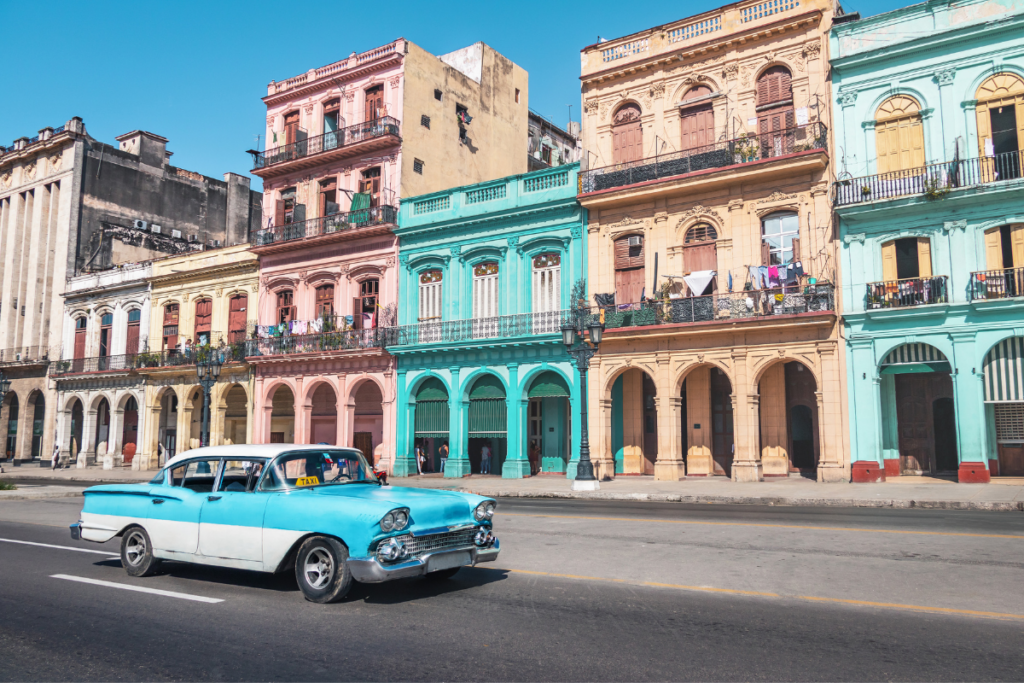 A Classic Car Driving Down the Colorful Streets of Old Havana in Cuba.