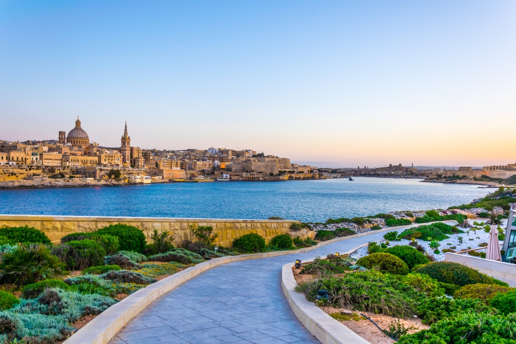 road leading up to the city of malta with the water in front