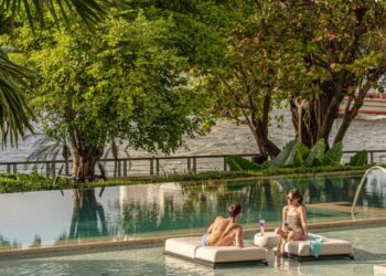 two people having cocktails by the pool at the Four Seasons Hotel Bangkok at Chao Phraya River