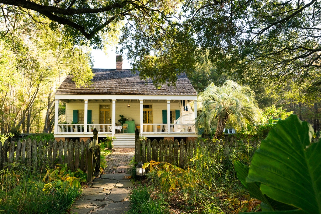 yellow airbnb in breaux bridge with greenery and a porch