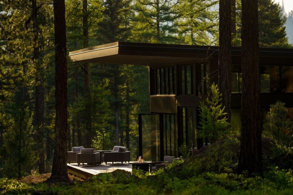 three lawn chairs and a room and a firplace surrounded by tree and greenery