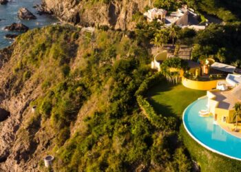 scenic view of yellow villa built atop the cliffs of careyes mexico coast