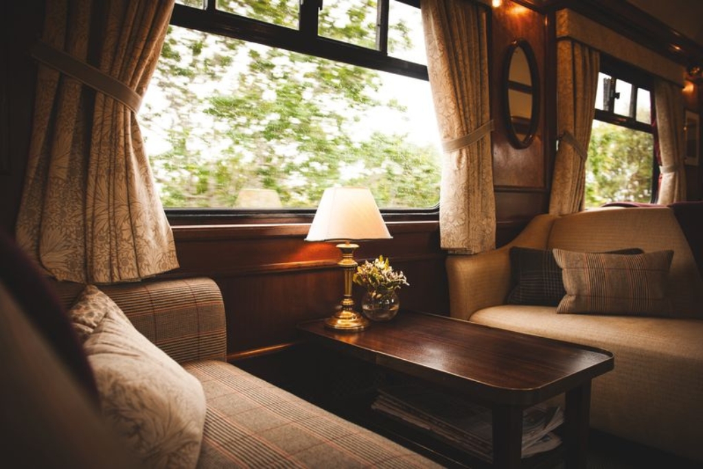 the royal scotsman luxury european train traveling through flower speckled prairies