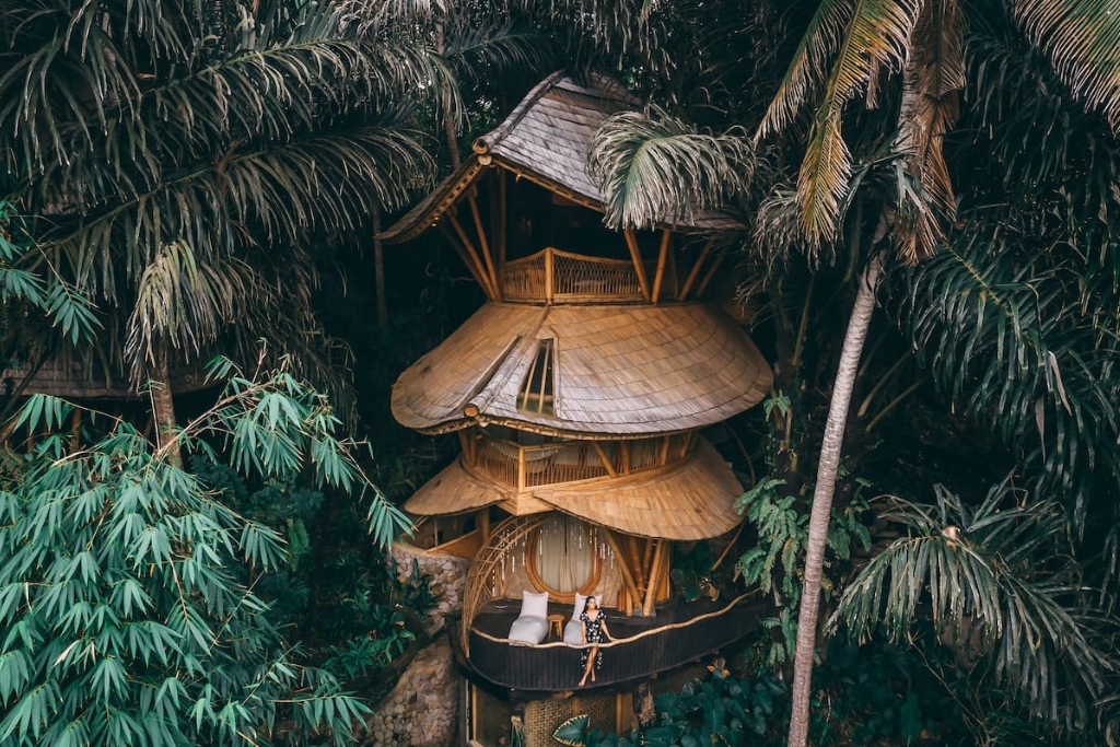 tall bamboo home in bali surrounded by green trees