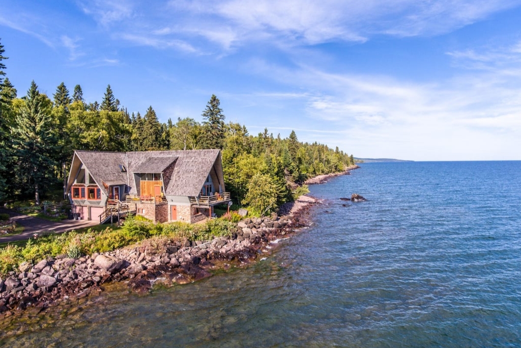 cabin by the water with forests and rocks and greenery