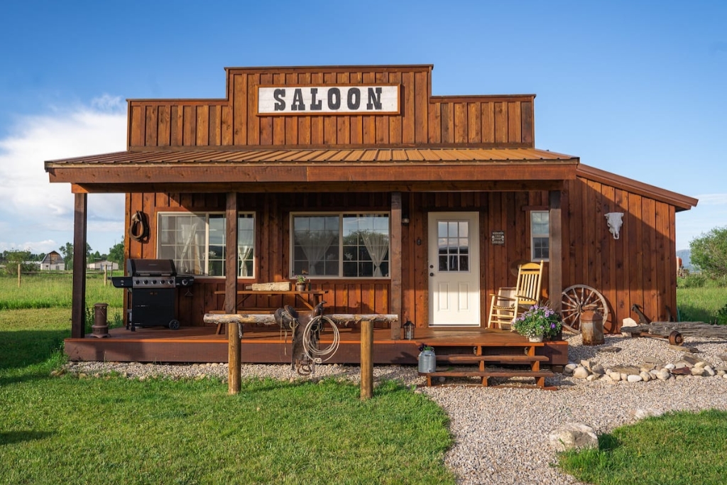 western saloon cabin with country a porch and rocking chair and horse back riding saddle and a bbq