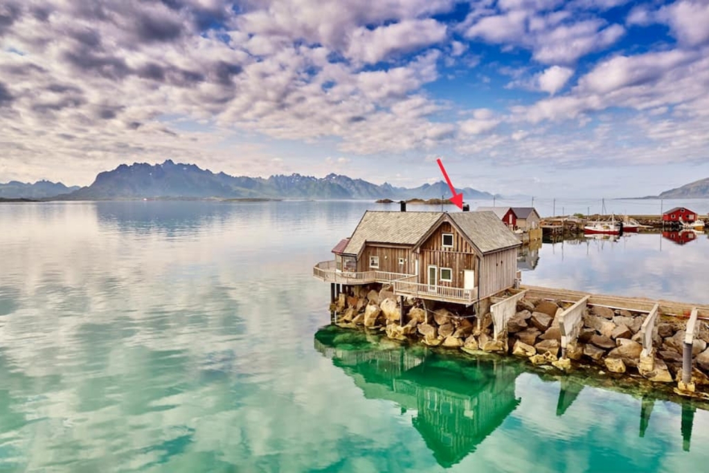 crystal clear waters in norway with a wooden cabin laying out on it