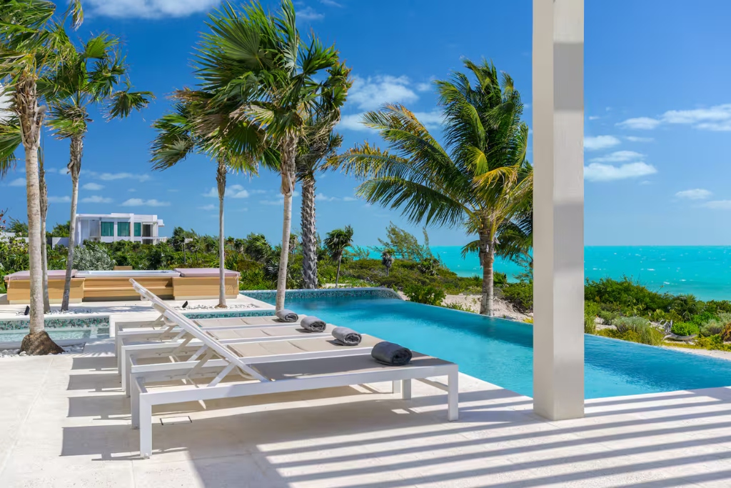 beach front villa in turks and cacios with infinity pool and sun chairs overlooking the ocean