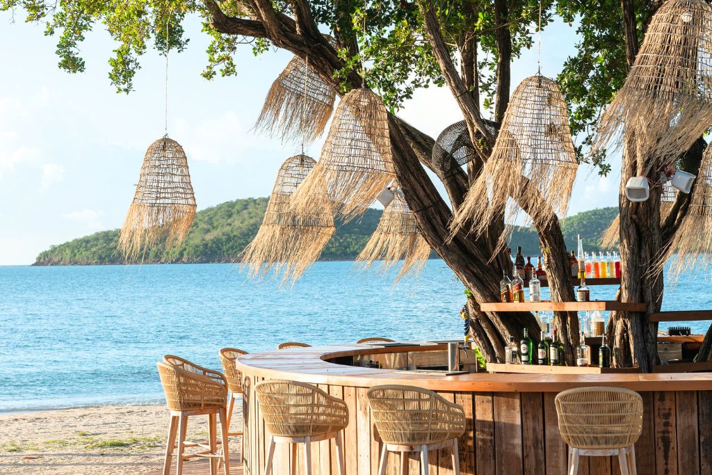 beach bar at hermitage bay antigua with ocean view and flowy straw mobiles