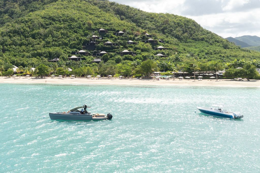 boats floating in water of hermitage bay with surrounding green mountain views