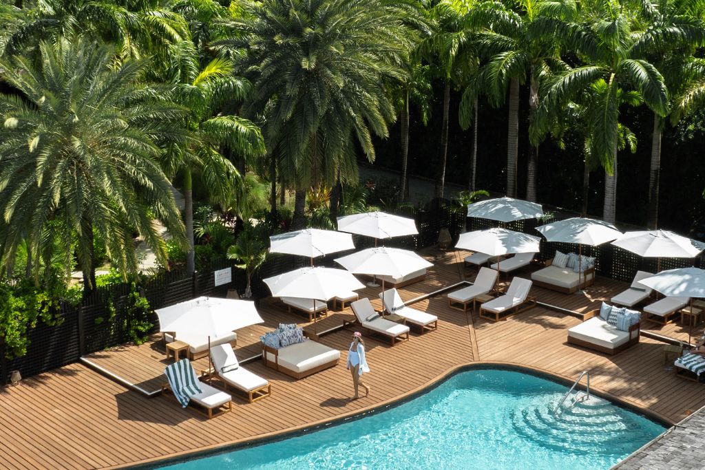 hermitage bay pool with surrounding palm trees and umbrella loungechairs