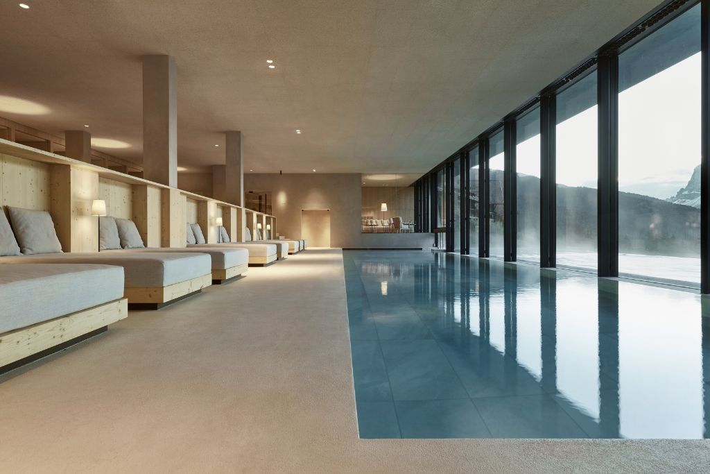 indoor pool with window view of mountains and spa beds at forestis spa