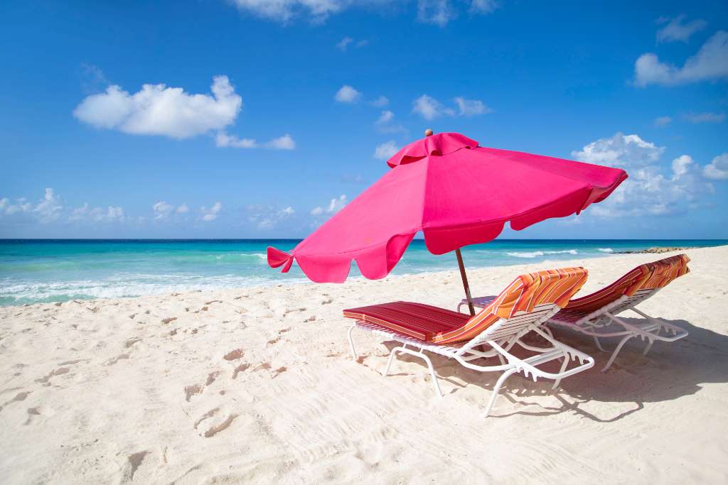 pink umbrella and orange sun loungers at o2 beach club and spa, barbados