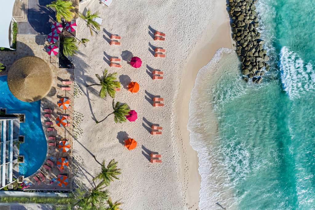 magenta pink and orange sun loungers and umbrellas at o2 beach club and resort in Barbados