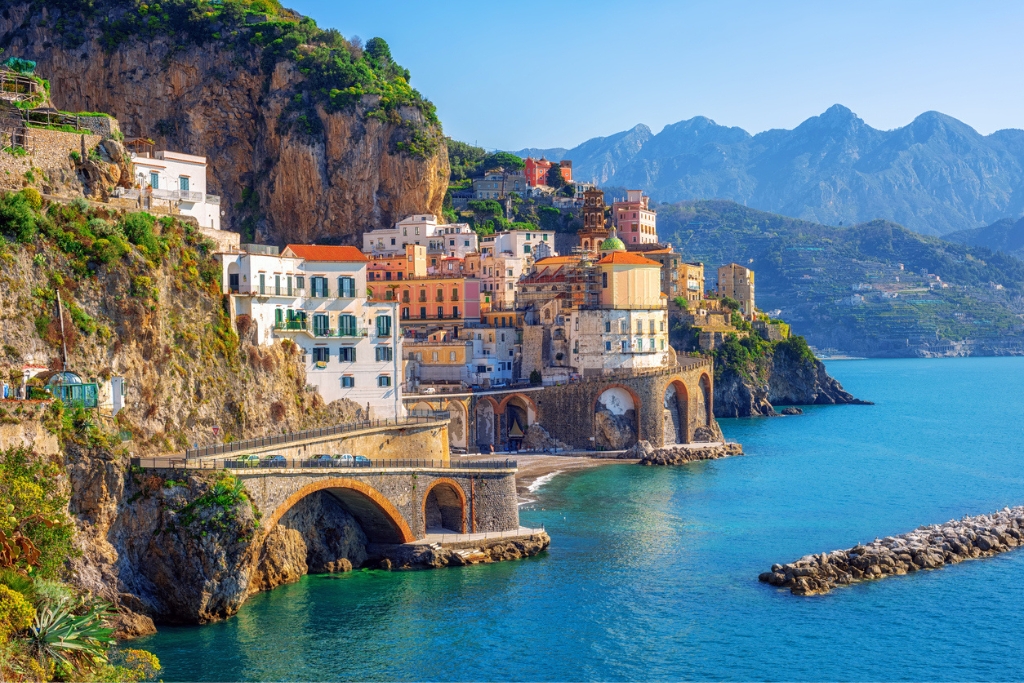 a cliffside in the amalfi coast with colorful building facing out on the blue water
