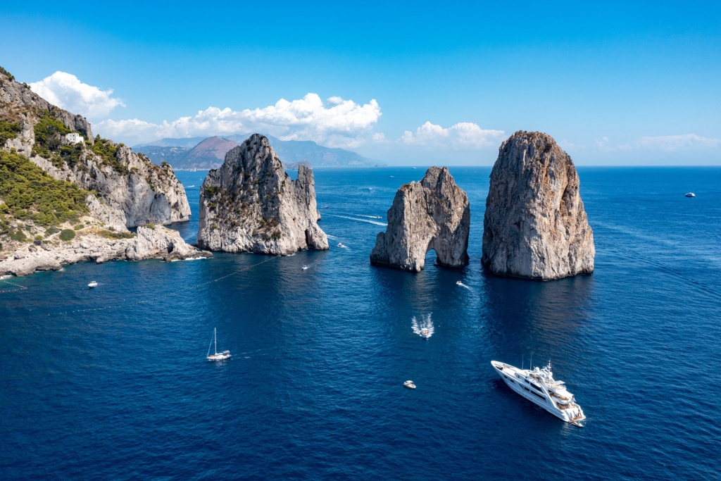 faraglioni rocks in capri italy surrounded by water and boats