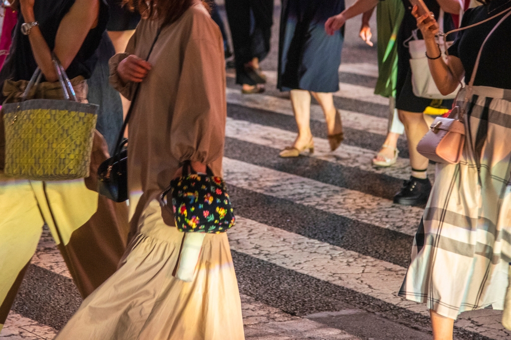 a group of women walking in tokyo with different vintage designer bags and jackets
