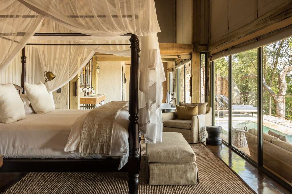 white canopied bed overlooking private plunge pool at singita ebony lodge