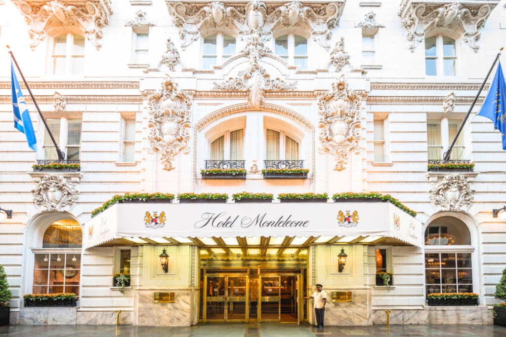 front of the hotel monteleone with a large awning and white structure with engravings throughout