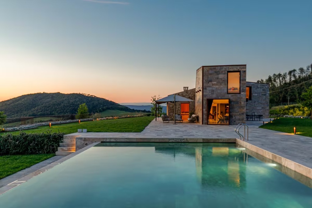 brick modern home in italy with a piil surrounded by greenery