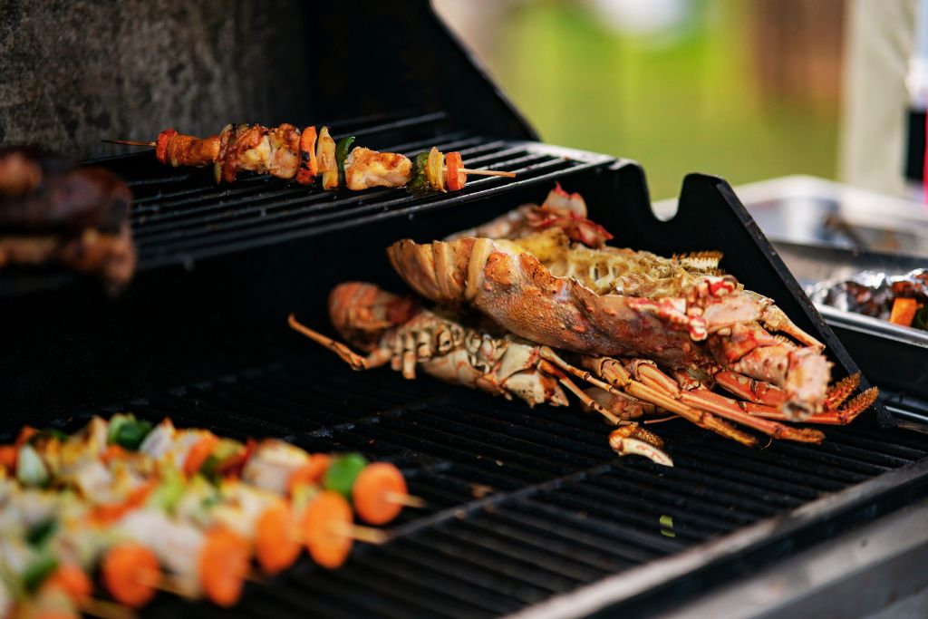 lobster and skewers being grilled