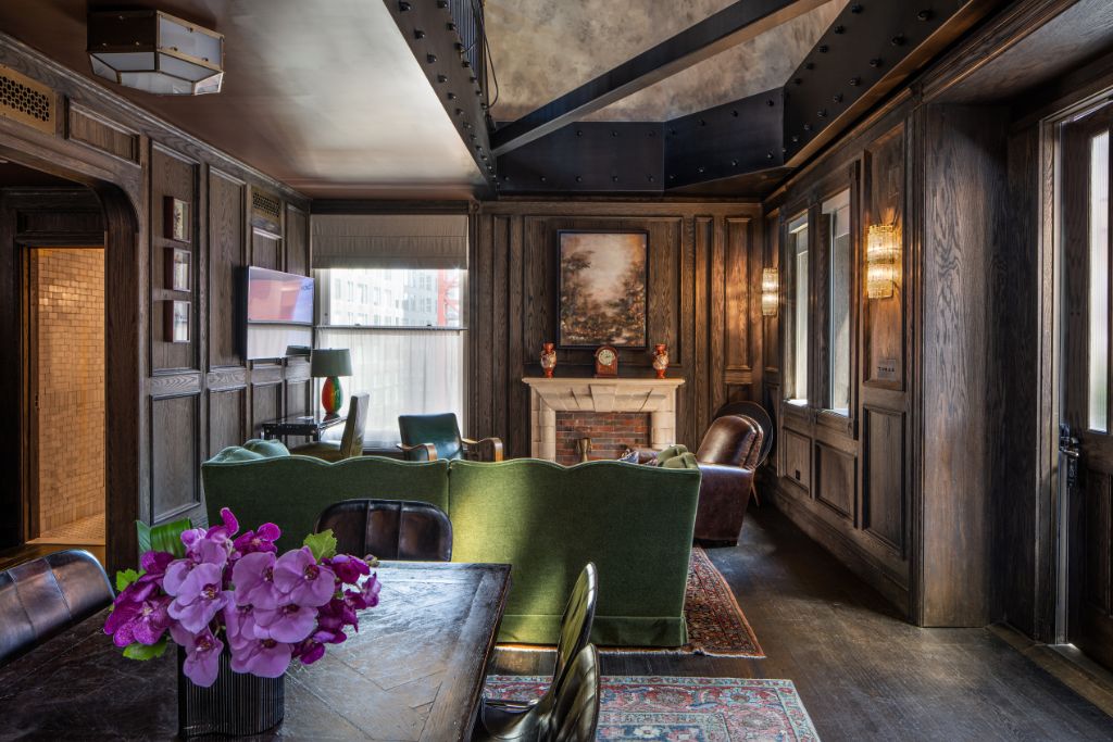 penthouse suite living room with fireplace, green couch, and industrial accents