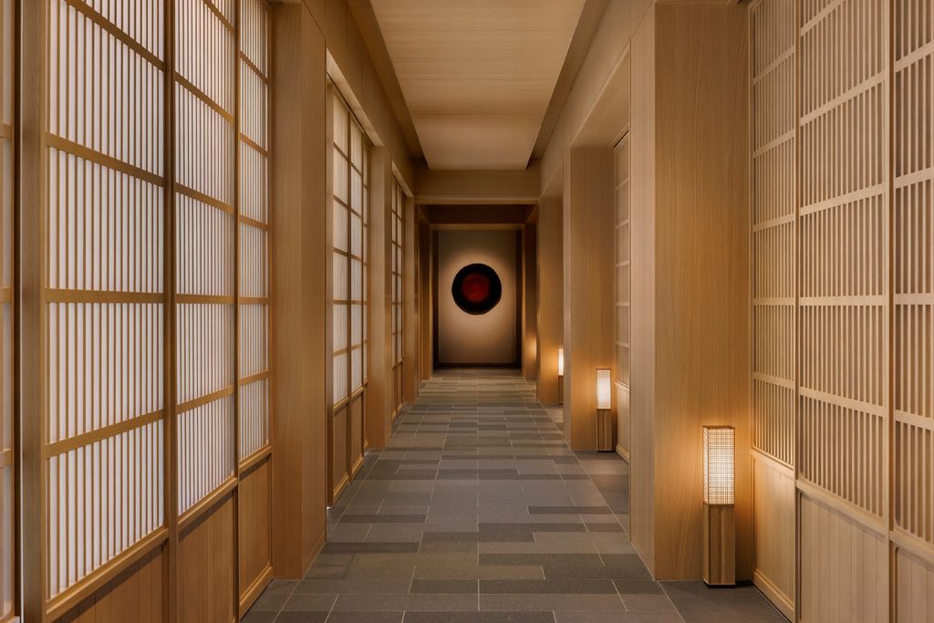 living room walkway with light wood paneling and serene red artwork