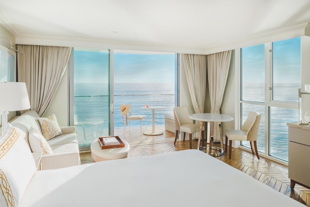 hotel room bed and seating area with balcony ocean view